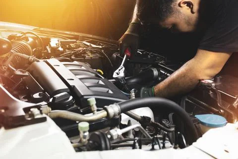 The Mechanic hand is fasten the bolt with the socket wrench Stock Photos