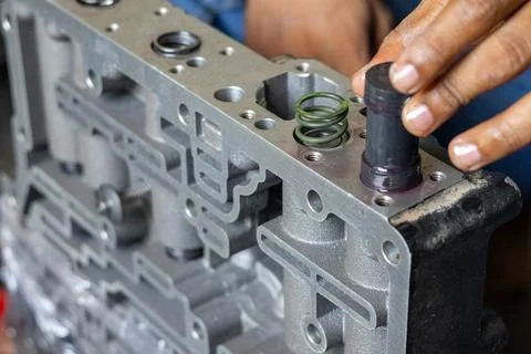 Mechanic Hand Inserting Plunger Valve Into Hydraulic Valve Body Unit. Stock Photos