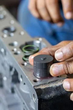 Mechanic Hand Inserting Plunger Valve Into Hydraulic Valve Body Unit. Stock Photos
