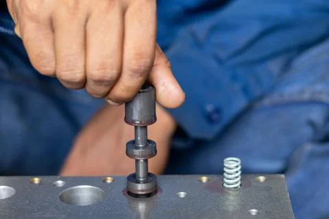 Mechanic Hand Inserting Spool Valve Shaft Into Hydraulic Control Valve Body. Stock Photos