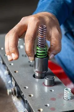 Mechanic Hand Inserting Valve Piston And Spring Assembly Into Hydraulic Block Stock Photos