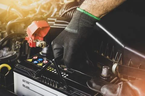 The Mechanic hand is pulling up an car old battery Stock Photos
