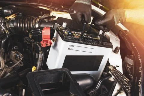 The Mechanic hand is pulling up an car old battery Stock Photos