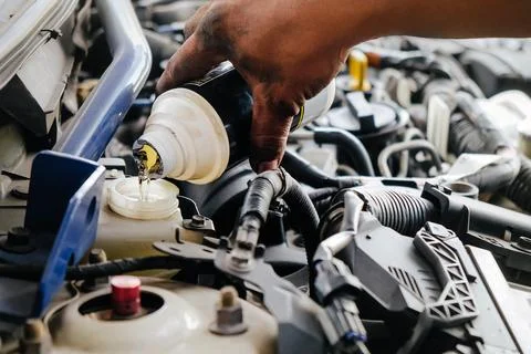 Mechanic hand servicing a car engine Stock Photos