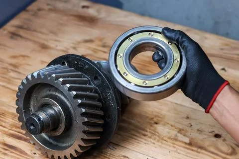 Mechanic Hand Showing Large Roller Ball Bearing Next to Industrial Helical .. Stock Photos
