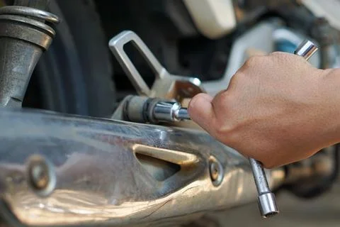 Mechanic Hand Using T-Handle Socket Wrench for Motorcycle Exhaust Repair 스톡 사진