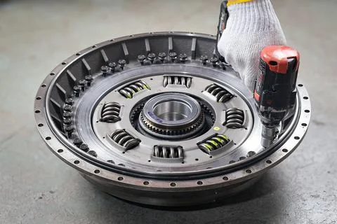 Mechanic hand using torque wrench ratchet tighten the torque converter bolts Stock Photos