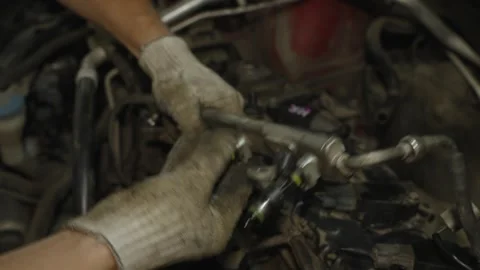 Mechanic hands in gloves installing a car fuel rail with fuel injectors. Stock Footage 340559425