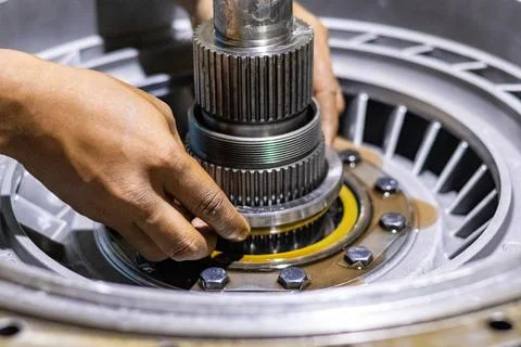 Mechanic hands install thrust bearing on transmission spline shaft in mecha.. Stock Photos