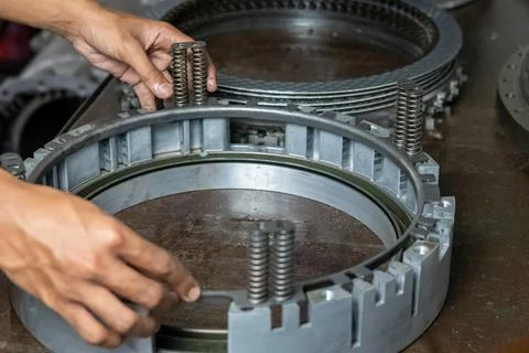 Mechanic hands installing clutch retainer ring on heavy transmission housing. Stock Photos