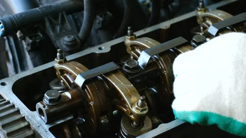 Mechanic hands meticulously inspect old engine testing each cylinder head valve Stock Footage 310521792