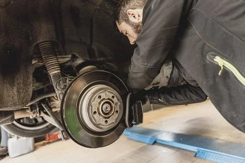 Mechanic Hands Replace Brake Pads on Car Skilled mechanic expertly replace... Stock Photos