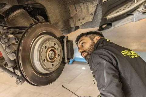  Mechanic Hands Replace Brake Pads on Car Milan, Italy 11 april 2023: Skil... Stock Photos