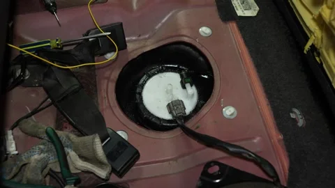 Mechanic hands replacing car fuel pump module under rear seat Stock Footage 340335685