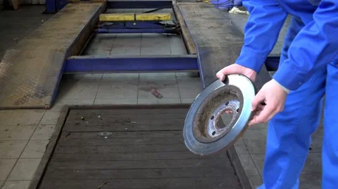 Mechanic hands showing worn rusty brake disk at garage Stock Footage 64780615