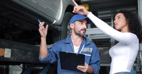 Mechanic having conversation with customer about car repairing budget cost Видео 157625378