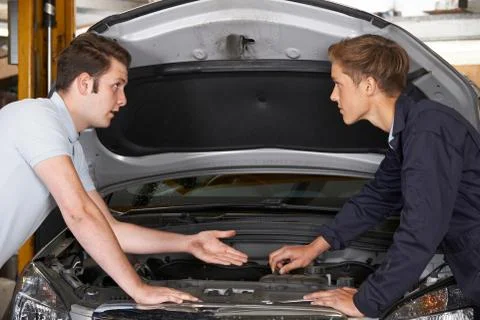 Mechanic Helping Apprentice To Fix Engine 库存照片