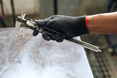 Mechanic Holding Digital Caliper in Workshop. Stock Photos