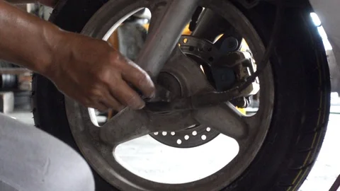 The mechanic is holding the nut into the wheel. 動画素材 108584378