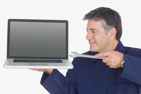 Mechanic holding wrench and laptop Stock Photos