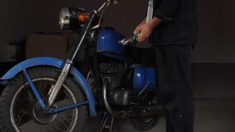 Mechanic holding wrenches and tools while working on a classic blue vintage Stock Footage 342766725