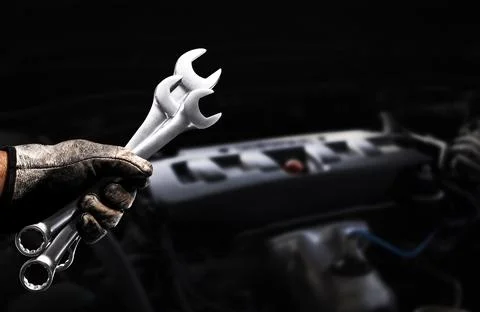 Mechanic holding wrenches during engine maintenance Foto stock