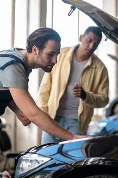 Mechanic identifying car problem and excited customer Stock Photos