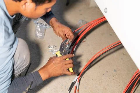 The mechanic is inserting the head of the wire using wire strippers Stock Photos