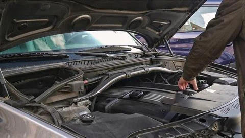 Mechanic inspecting car engine for potential issues Stock Photos