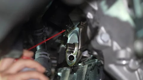 Mechanic Inspecting Car Engine with Red Tool. Mood: Focused; Setting: Stock Footage 345708239