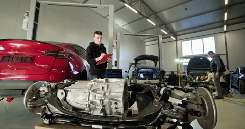Mechanic Inspecting Electric Car Engine In Auto Repair Shop Stock Footage 277263790