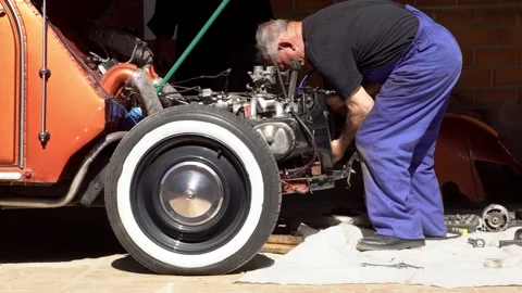 A mechanic inspecting the engine of a classic car, vintage vehicles on workshop Video stock 312025288