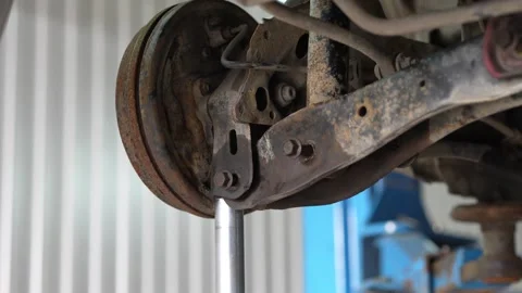 Mechanic Inspecting Rusty Brake Disc and Caliper on Car Wheel Hub Stock Footage 345569167