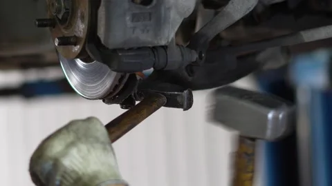 Mechanic Inspecting Rusty Brake Disc and Caliper on Car Wheel Hub Stock Footage 345570986