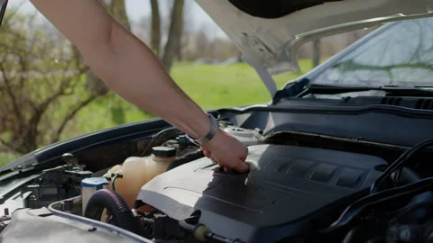 Mechanic inspecting vehicle engine components outdoors, demonstrating repair Stock Footage 312517815