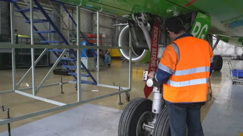 A mechanic inspects front strut passenger aircraft. 4K Stock Footage 95647442