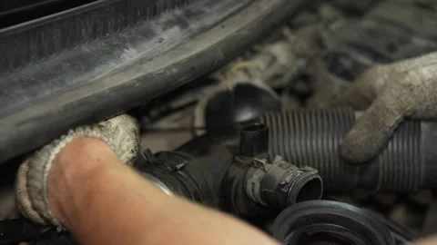 Mechanic installing air intake hose onto car throttle body assembly. Stock Footage 341487199