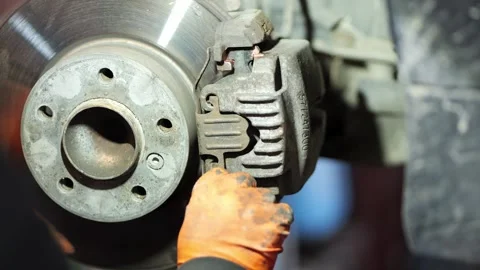 Mechanic Installing Brake Caliper on Disc Close Up 1 Stock Footage 331704188