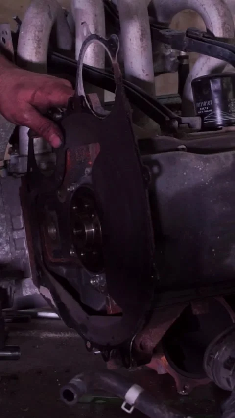 Mechanic installing engine gasket and rear plate in workshop Stock Footage 346396822