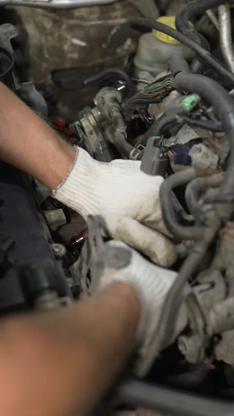 A mechanic installing a fuel rail with injectors into engine. Stock Footage 342259484