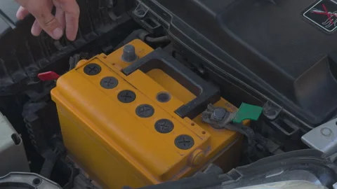 Mechanic installing new car battery under the hood Stock Footage 338408708