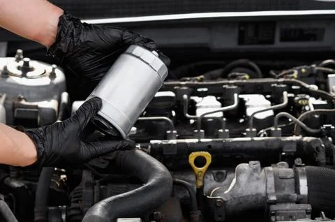 Mechanic installing new fuel filter into car engine bay close up, auto Stock Photos