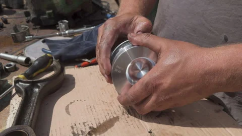 Mechanic installing piston rings on engine component Stock Footage 338411186