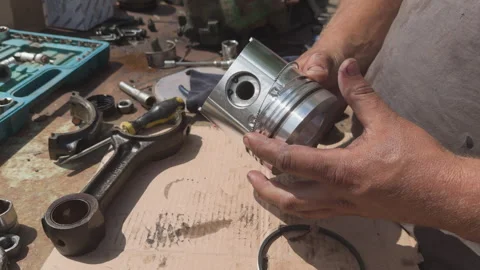 Mechanic installing piston rings on engine component Stock Footage 338411201