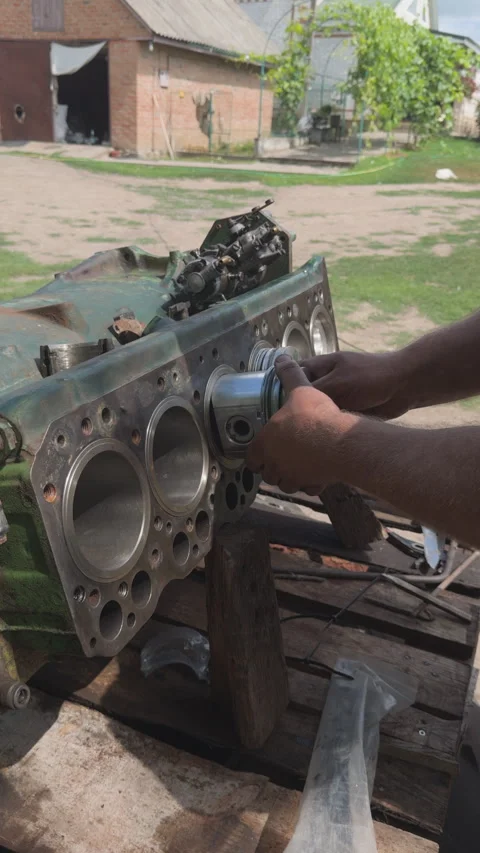 Mechanic installing piston into a tractor engine block Stock Footage 338411331