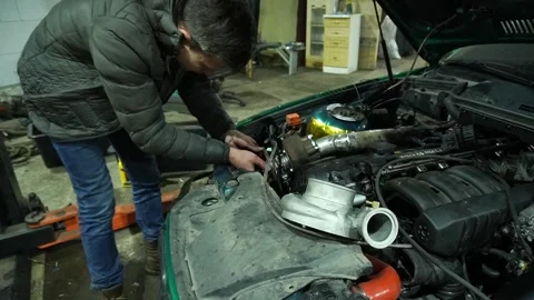 Mechanic installs exhaust pipe Stock Footage 235680075