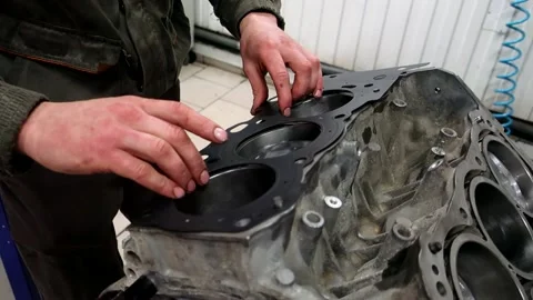The mechanic installs the gasket on the engine block Stock Footage 150266714