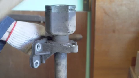 Mechanic knocks down the bearing bracket from drive shaft of the vehicle Stock Footage 107007917