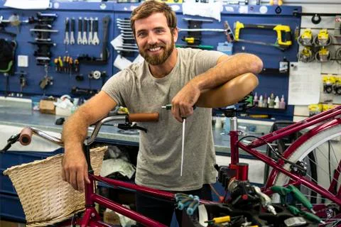 Mechanic leaning on bicycle Stock Photos