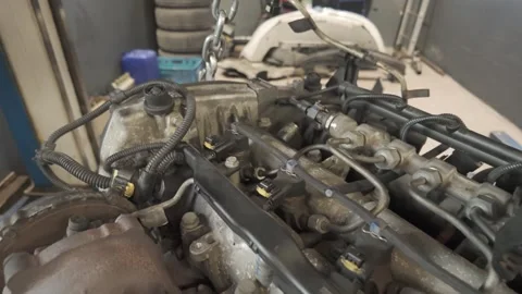 Mechanic lifting car engine with chain in garage Video stock 307422335